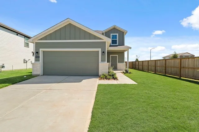 a front view of a house with a yard and garage