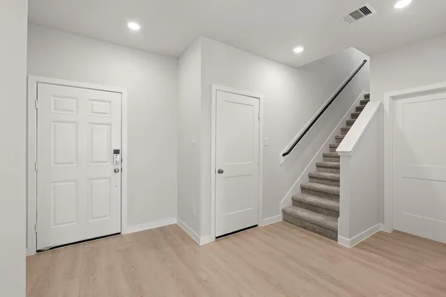 a kitchen with a refrigerator and white cabinets