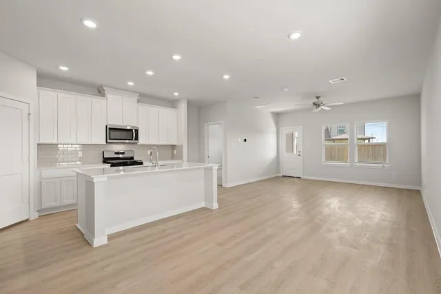 a view of kitchen with stainless steel appliances granite countertop cabinets and wooden floor