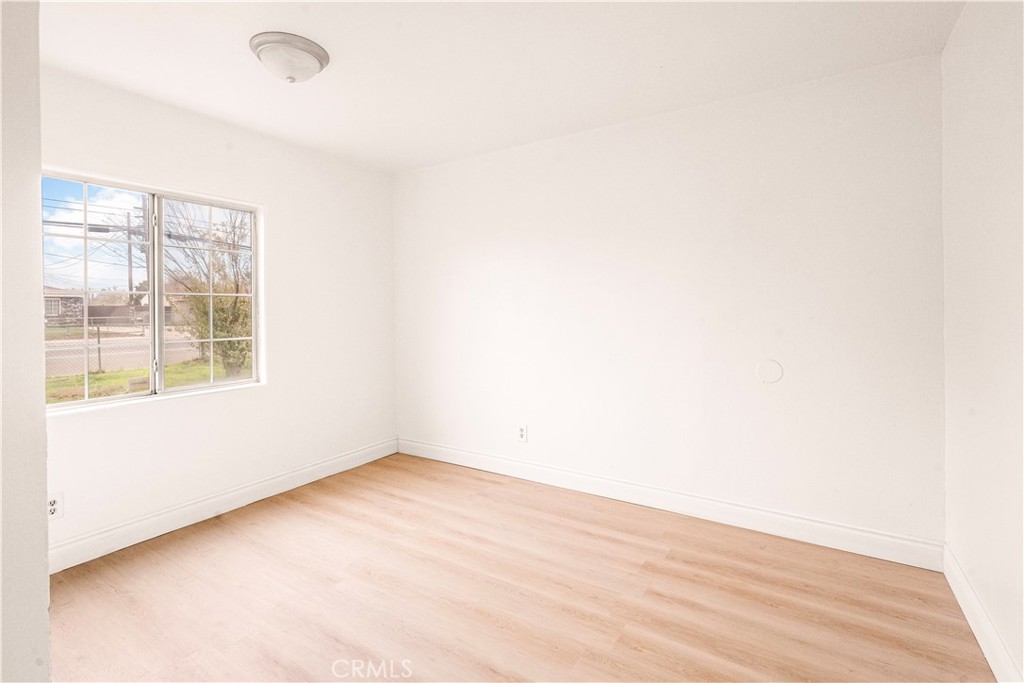 407 4th Street Bakersfield, CA 93304 - Photo 11 of 31 an empty room with wooden floor and windows