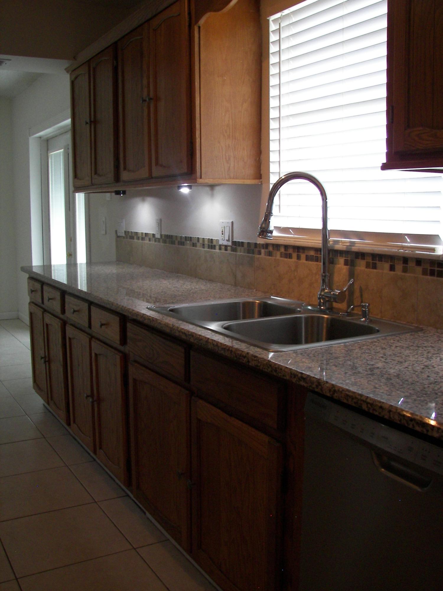 650 Northwest Selvitz Road Port St. Lucie, FL 34983 - Photo 11 of 24 a kitchen with granite countertop a sink a window and cabinets