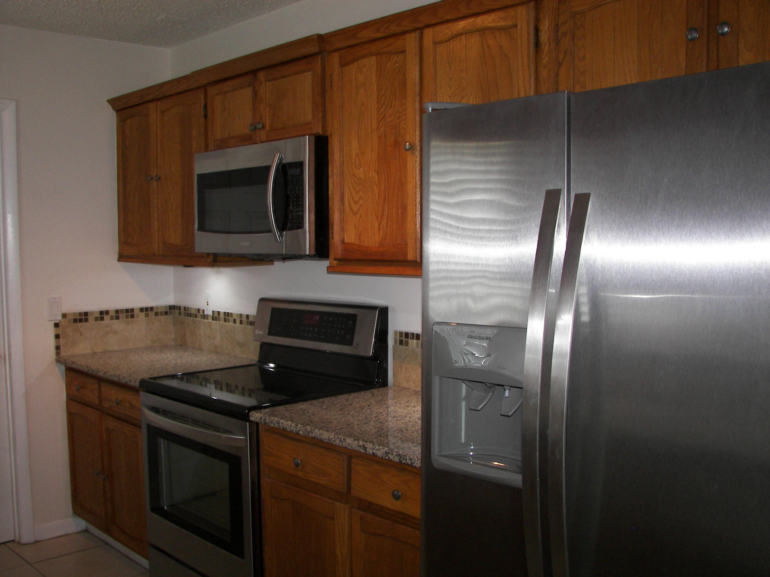 650 Northwest Selvitz Road Port St. Lucie, FL 34983 - Photo 12 of 24 a kitchen with granite countertop stainless steel appliances and wooden cabinets