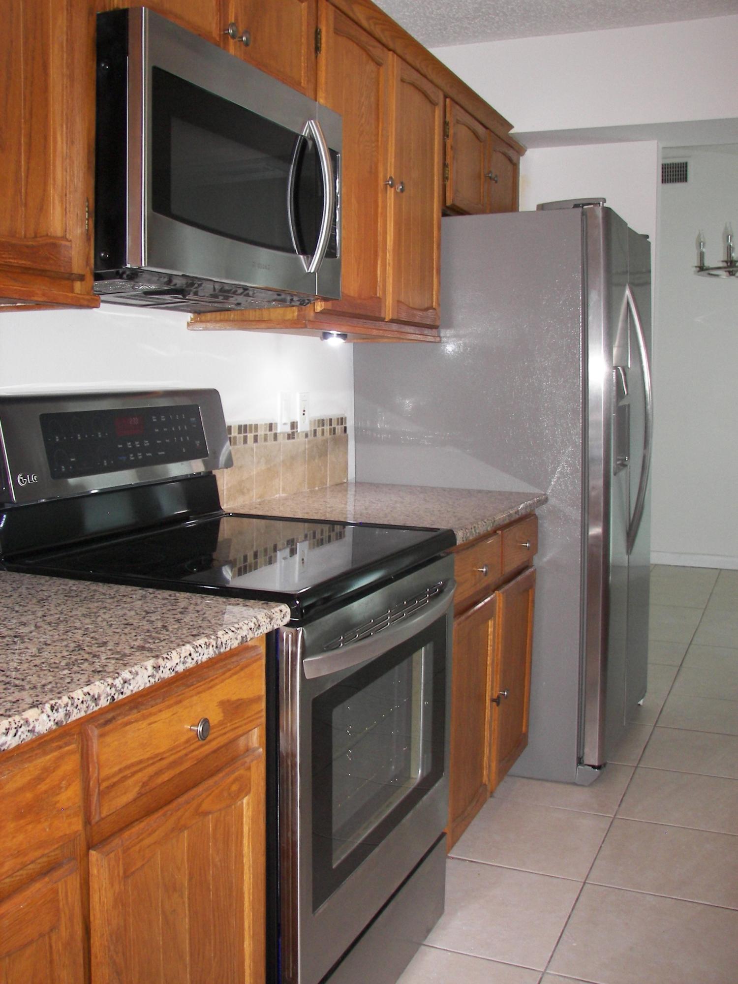 650 Northwest Selvitz Road Port St. Lucie, FL 34983 - Photo 13 of 24 a kitchen with stainless steel appliances granite countertop a stove microwave and sink
