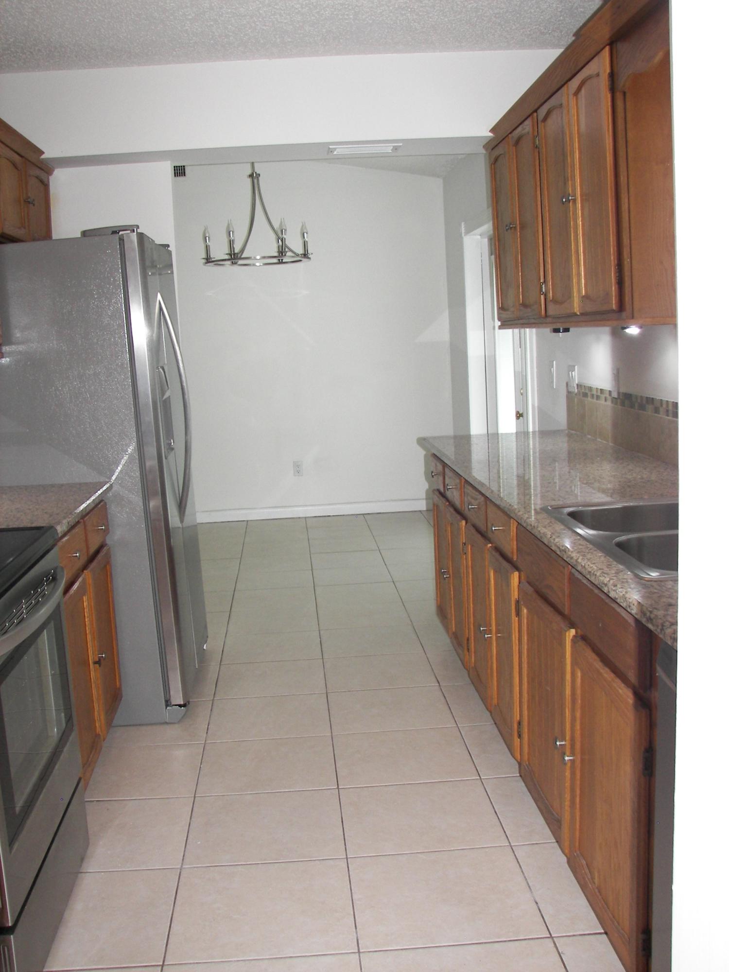 650 Northwest Selvitz Road Port St. Lucie, FL 34983 - Photo 15 of 24 a kitchen with stainless steel appliances granite countertop a refrigerator and a stove