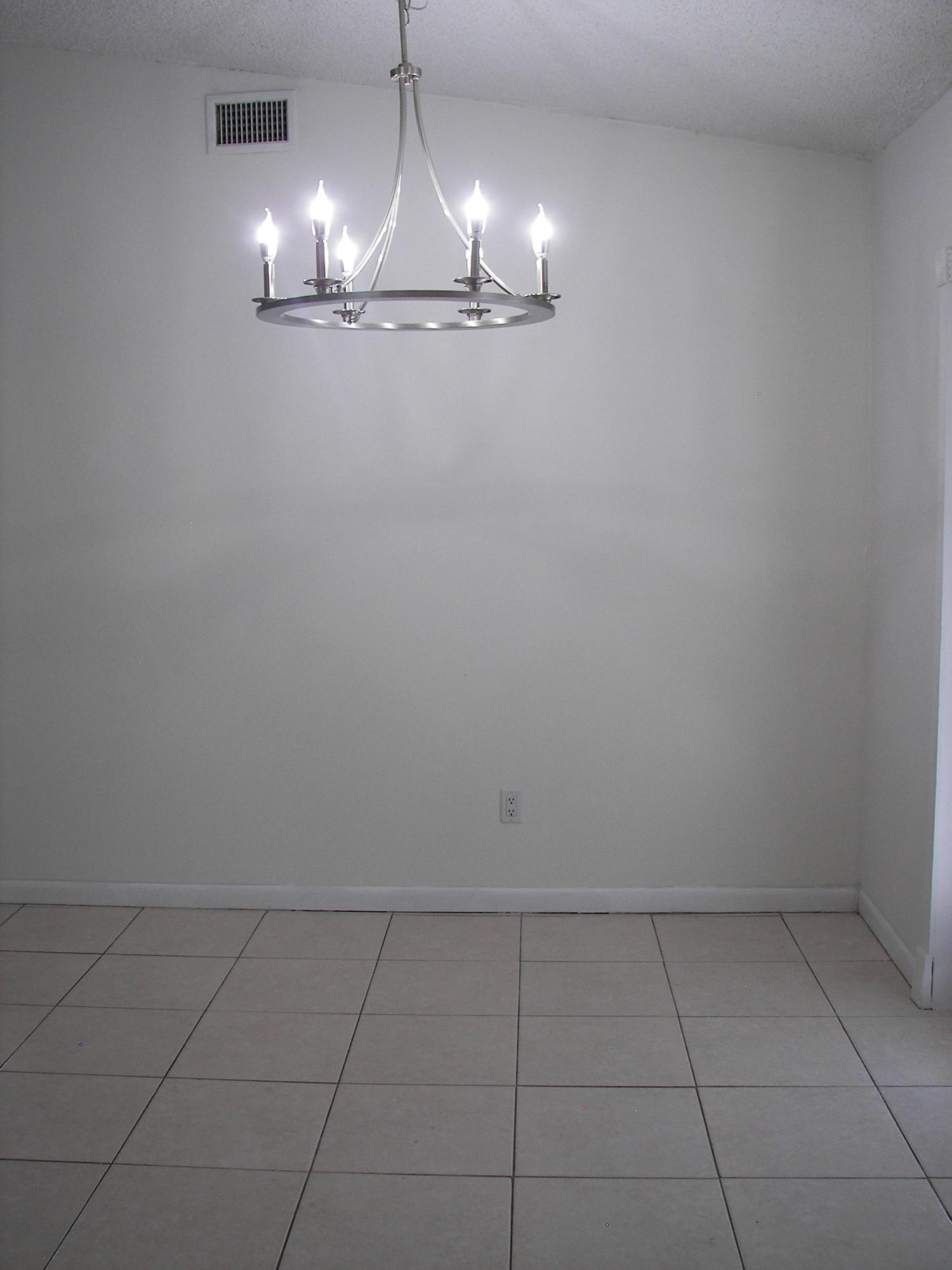 650 Northwest Selvitz Road Port St. Lucie, FL 34983 - Photo 7 of 24 an empty room with chandelier fan