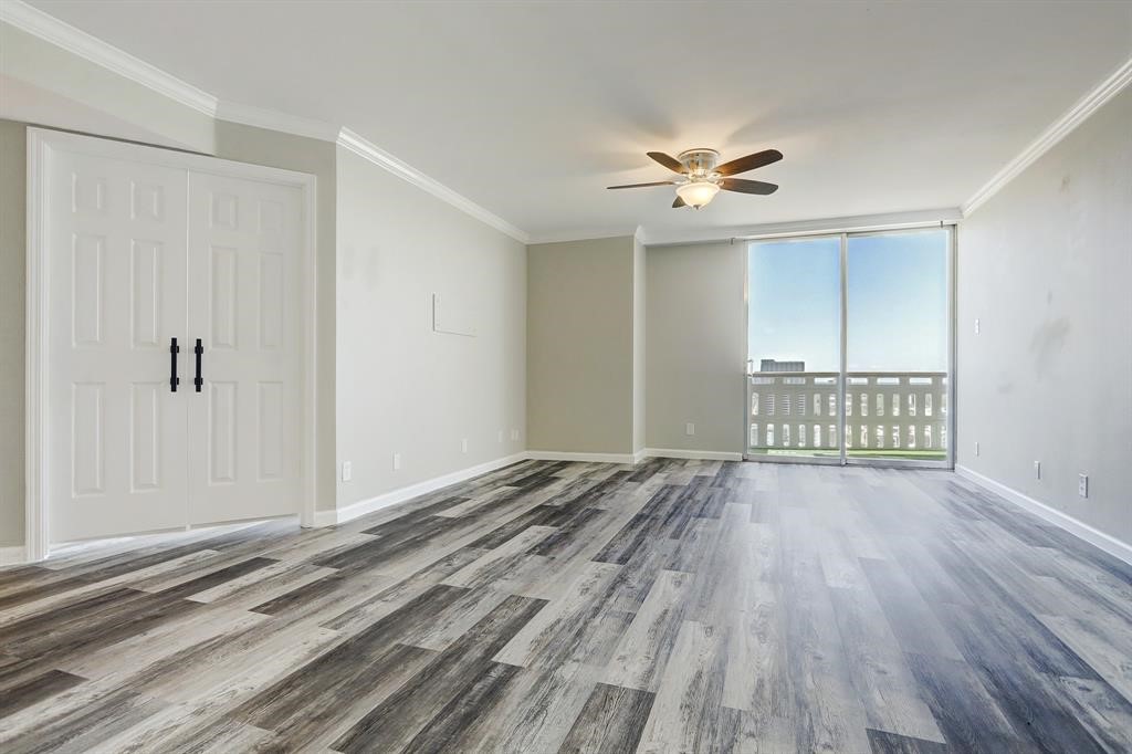 2016 Main Street, Unit 2204 Houston, TX 77002 - Photo 3 of 21 a view of an empty room with wooden floor and a ceiling fan