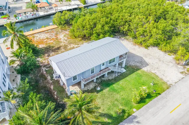 an aerial view of a house with a garden and lake view