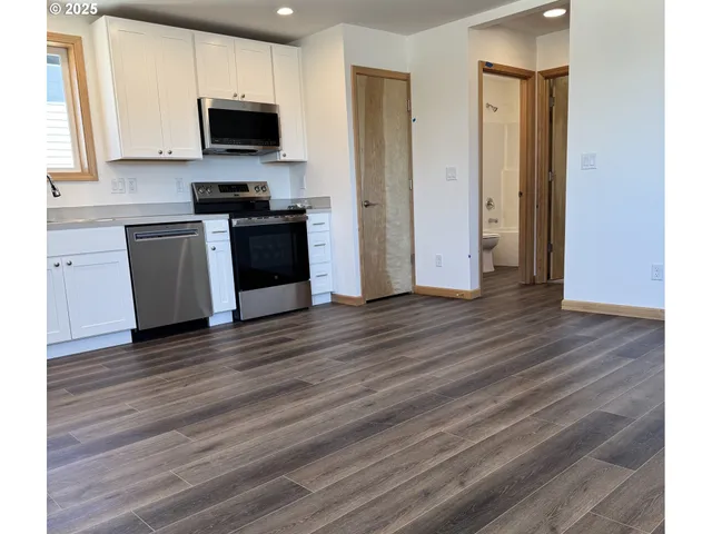 a kitchen with wooden floors and black appliances