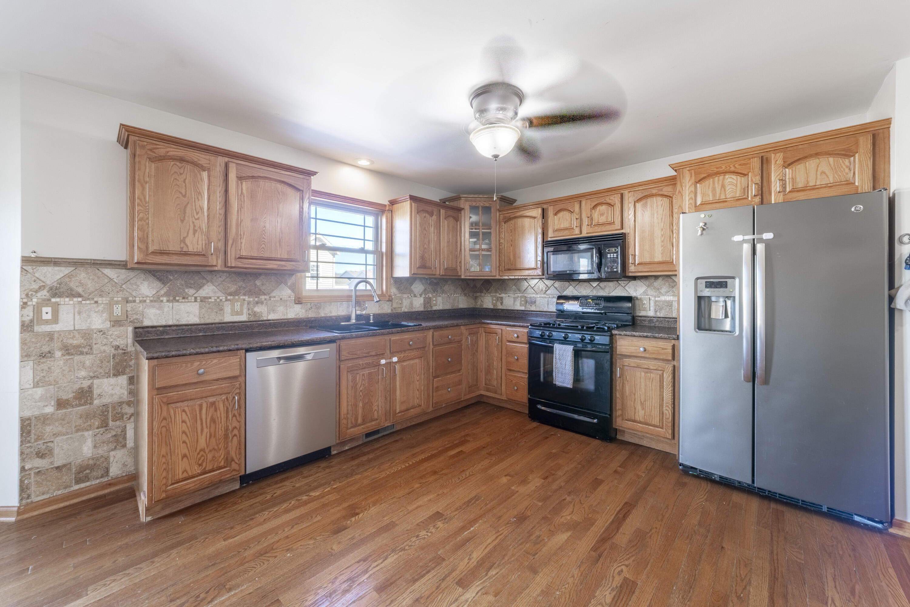 704 Coach Light Lane Lowell, IN 46356 - Photo 15 of 34 a kitchen with granite countertop wooden floors stainless steel appliances and a counter space