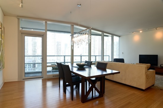 340 East Randolph Street, Unit 2402 Chicago, IL 60601 - Photo 2 of 26 a bedroom with a large window and a table