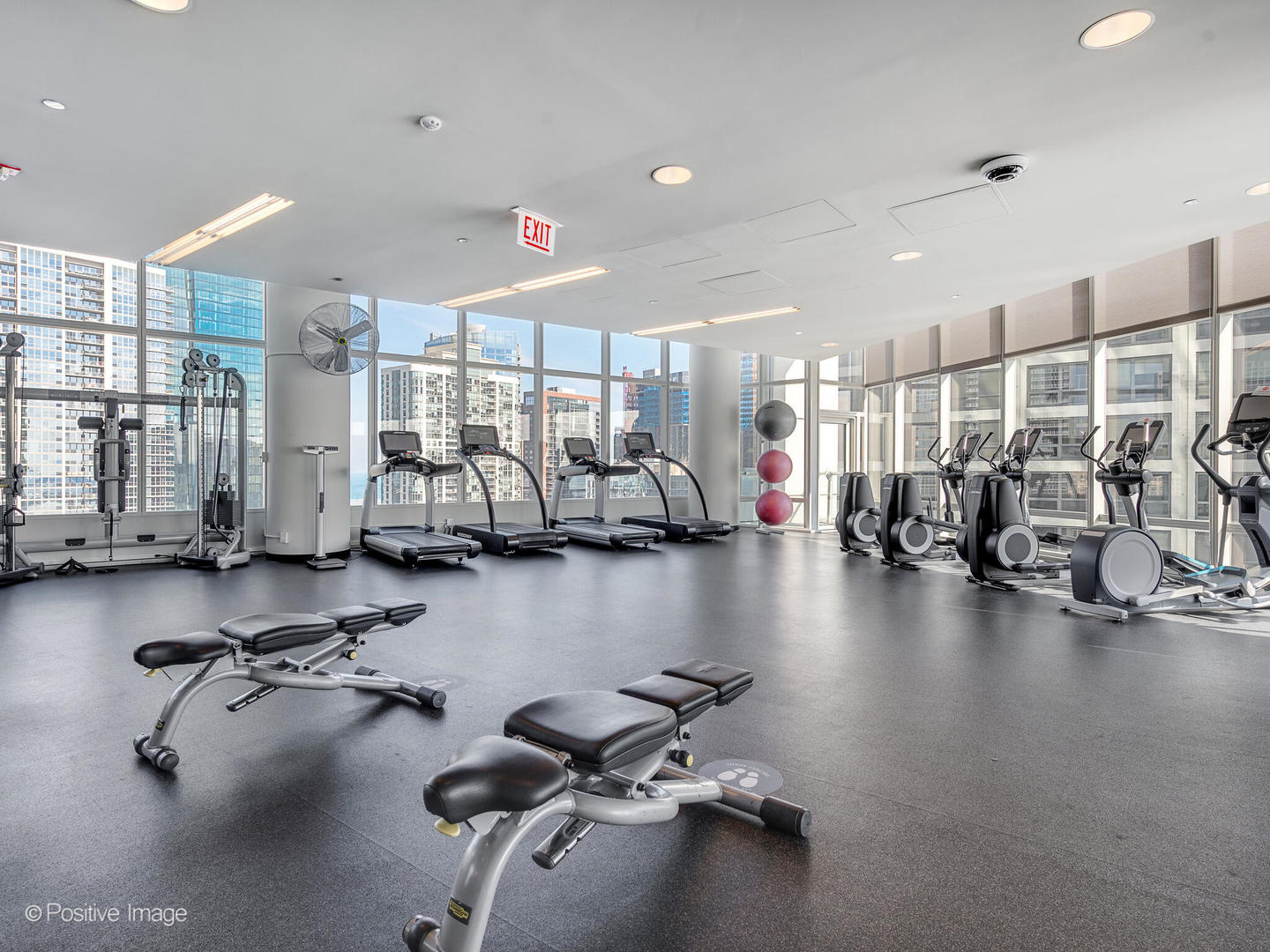 340 East Randolph Street, Unit 2402 Chicago, IL 60601 - Photo 22 of 26 a view of a room with gym equipment and large windows