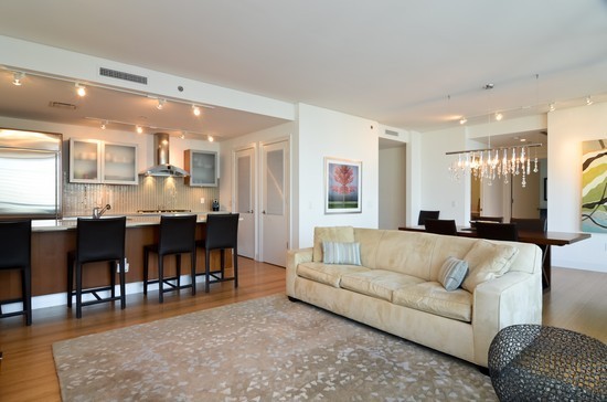 340 East Randolph Street, Unit 2402 Chicago, IL 60601 - Photo 4 of 26 a living room with furniture a dining table and a couches with wooden floor