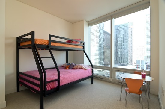 340 East Randolph Street, Unit 2402 Chicago, IL 60601 - Photo 9 of 26 a bedroom with furniture and a window