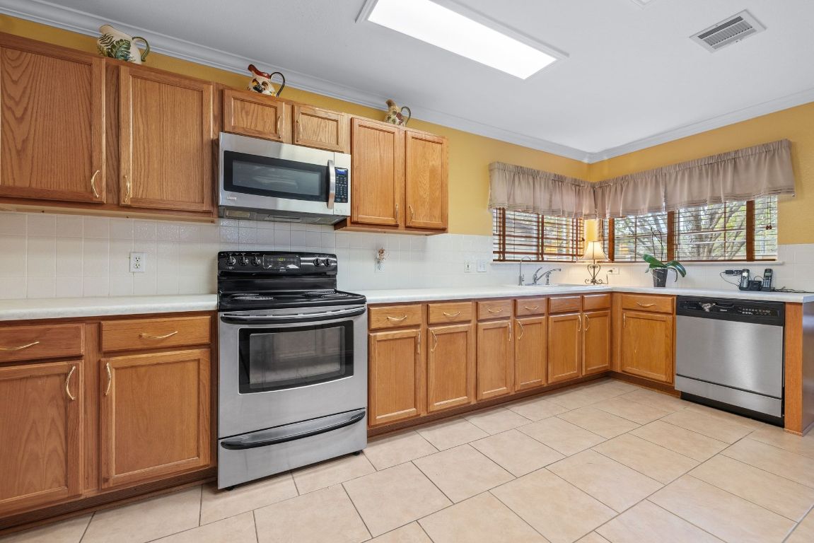 2210 Rachel Ridge Cedar Park, TX 78613 - Photo 16 of 40 a kitchen with stainless steel appliances granite countertop a stove sink microwave and window