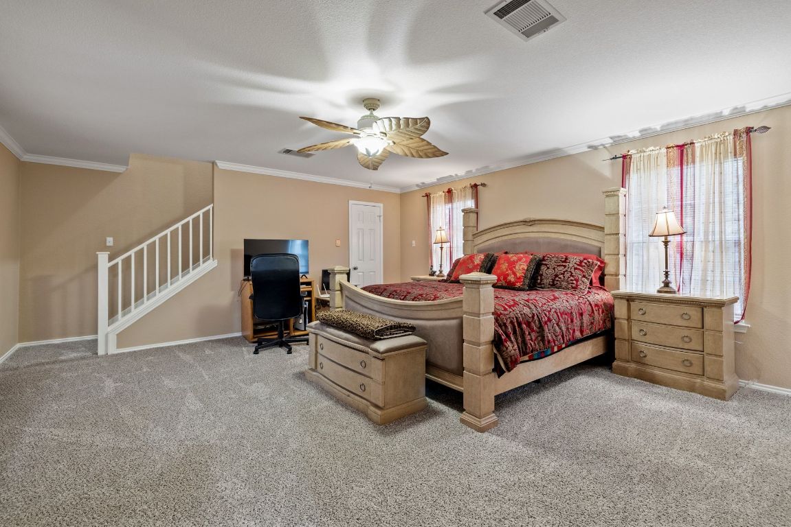 2210 Rachel Ridge Cedar Park, TX 78613 - Photo 19 of 40 a bedroom with a bed and a chandelier