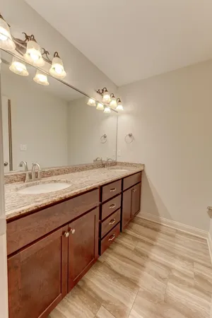 a spacious bathroom with a granite countertop double vanity sink and a mirror