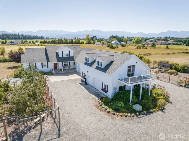 an aerial view of a house with outdoor space and lake view in back