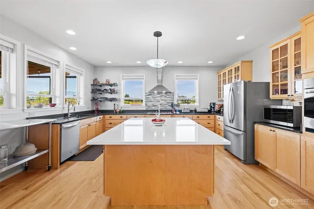 a large kitchen with stainless steel appliances granite countertop a refrigerator a oven and a sink