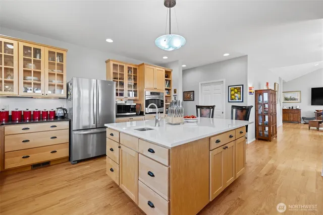 a kitchen with stainless steel appliances kitchen island granite countertop a refrigerator and a stove