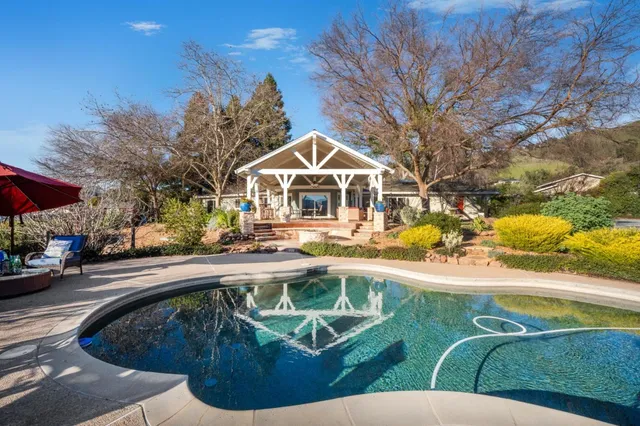 a view of a house with pool and chairs