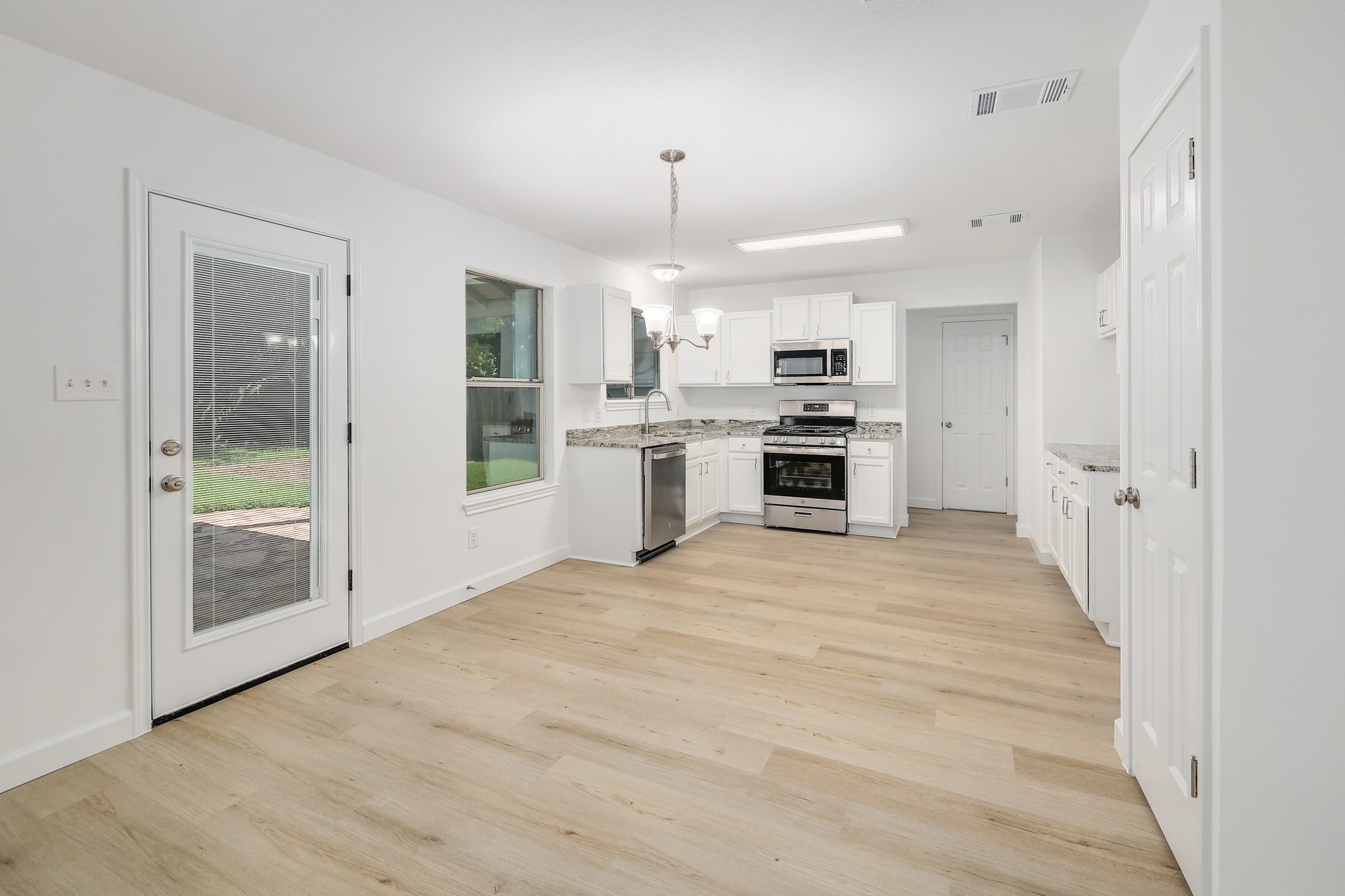 709 Los Robles Road Leander, TX 78641 - Photo 10 of 26 A well-lit kitchen with sleek stainless steel appliances and light wood flooring offers a modern and inviting space.