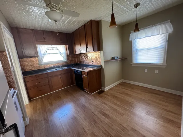 a kitchen with stainless steel appliances granite countertop wooden floors and sink
