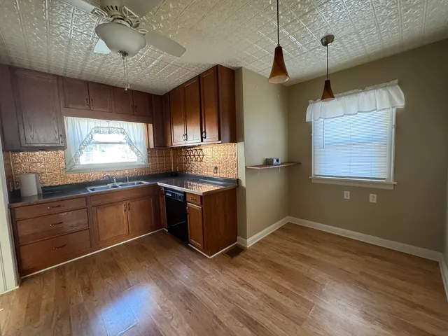 a kitchen with granite countertop a stove and wooden cabinets