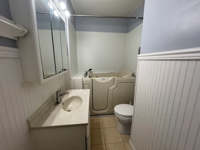 a bathroom with a toilet sink and mirror