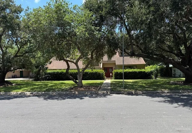 a view of a house with a big yard and large trees