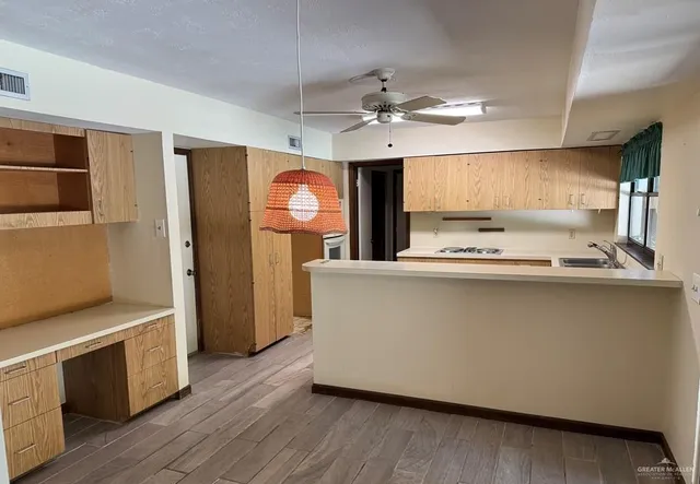 a living room with stainless steel appliances kitchen island furniture and wooden floor