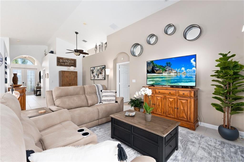 2688 Southeast Castle Pine Place Stuart, FL 34997 - Photo 15 of 49 a living room with furniture a flat screen tv and a potted plant