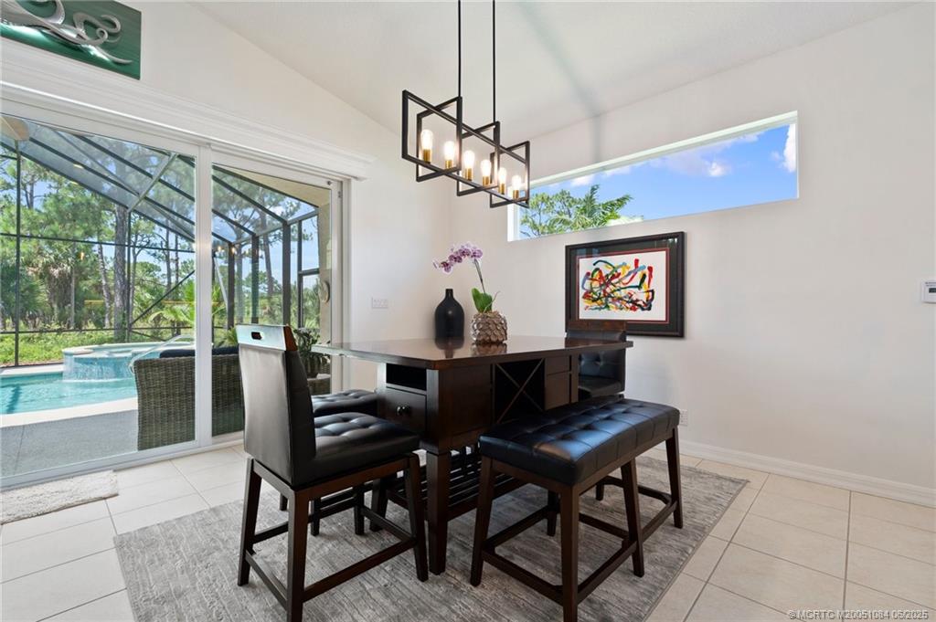 2688 Southeast Castle Pine Place Stuart, FL 34997 - Photo 17 of 49 a living room with couch a dining table and a chandelier