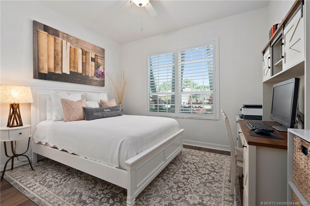2688 Southeast Castle Pine Place Stuart, FL 34997 - Photo 23 of 49 a bedroom with a bed flat screen tv and a window
