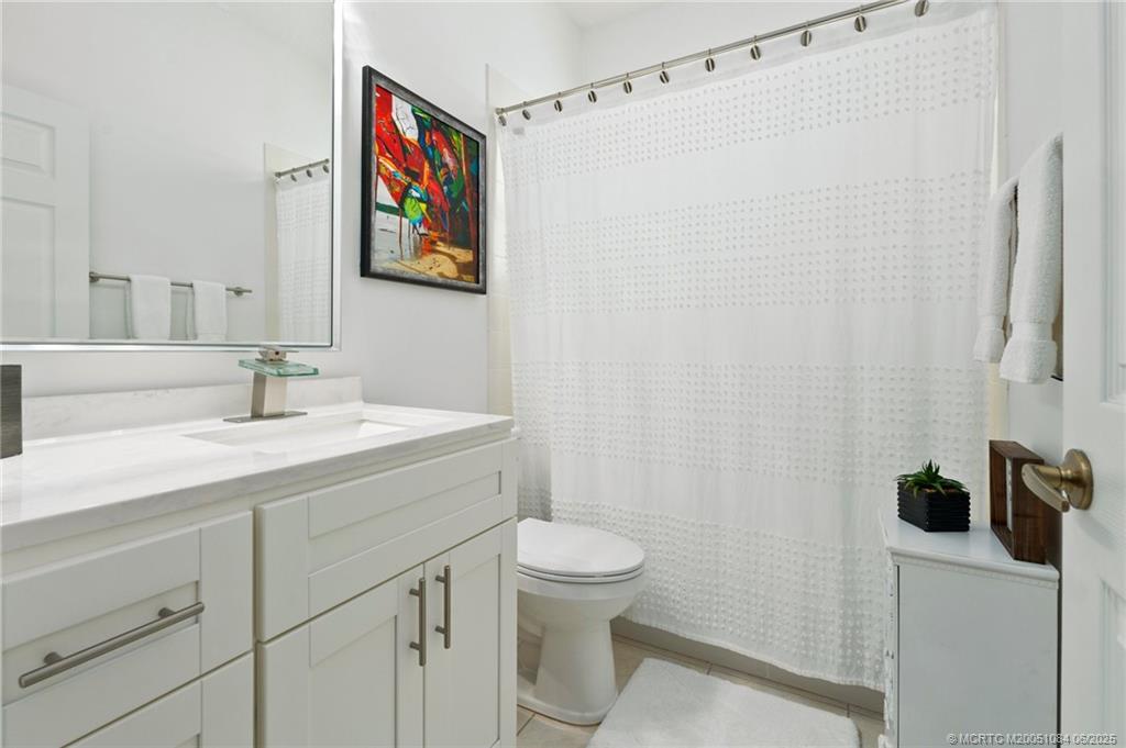 2688 Southeast Castle Pine Place Stuart, FL 34997 - Photo 24 of 49 a bathroom with a sink a toilet and shower