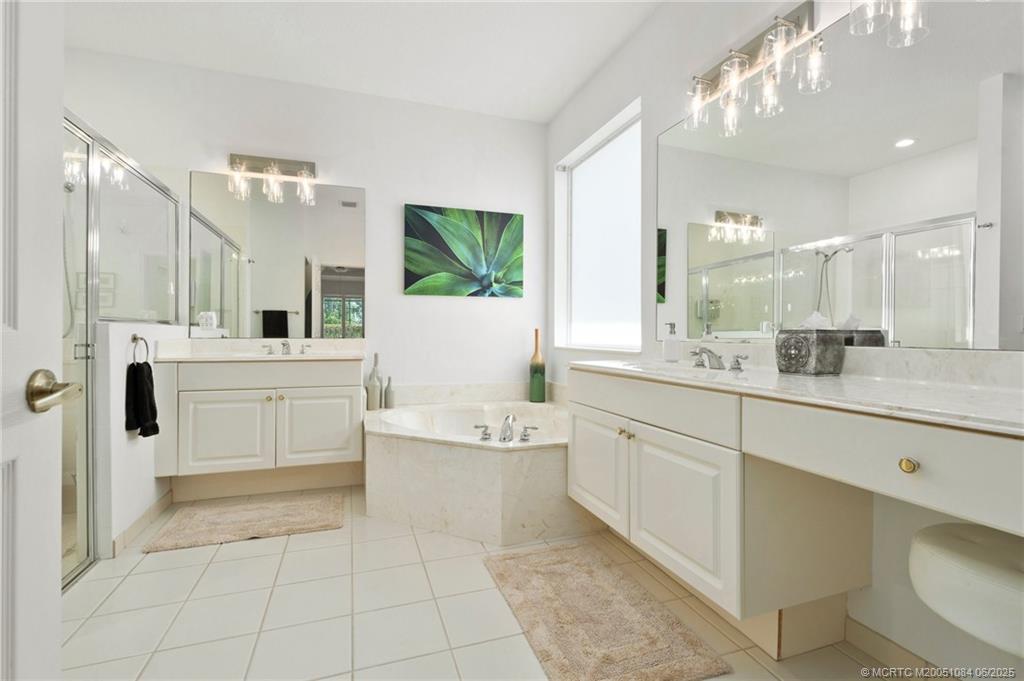2688 Southeast Castle Pine Place Stuart, FL 34997 - Photo 28 of 49 a large bathroom with a double vanity sink a mirror and a bathtub