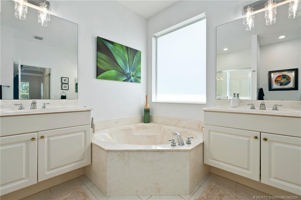 2688 Southeast Castle Pine Place Stuart, FL 34997 - Photo 29 of 49 a bathroom with a bathtub sink and mirror