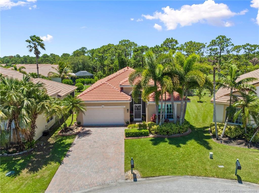 2688 Southeast Castle Pine Place Stuart, FL 34997 - Photo 3 of 49 a front view of a house with a yard and potted plants