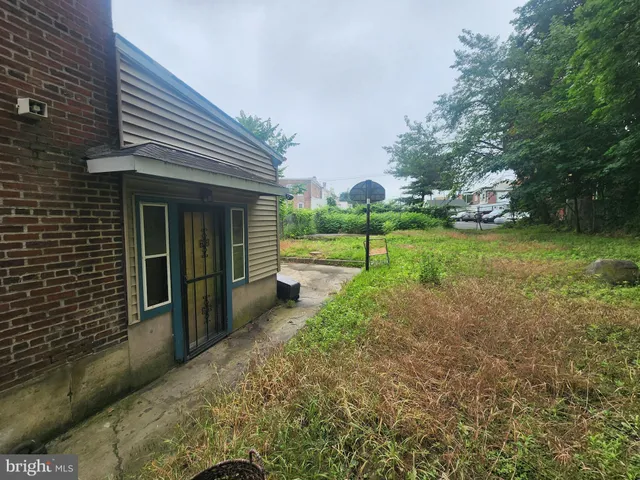 a view of a house with backyard and trees