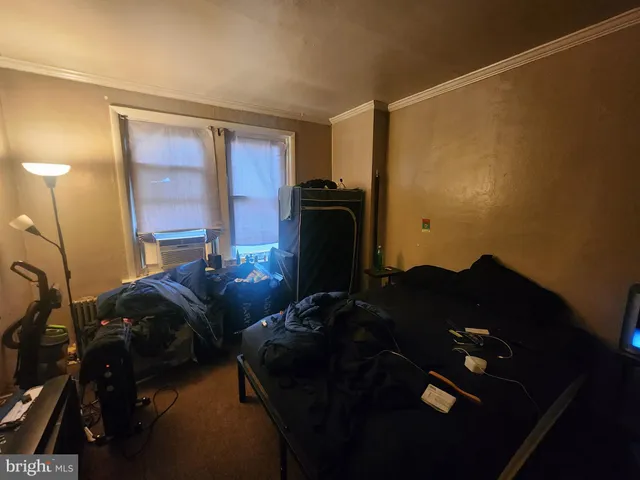 a room with furniture a air conditioner vent and a window