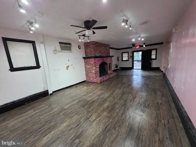 a view of a livingroom with a red fan & a window