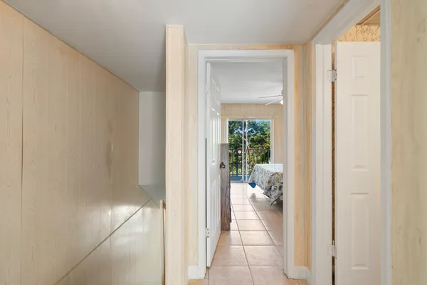 a view of a hallway with white walls and furniture