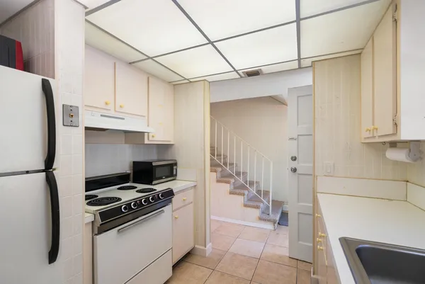 a kitchen with stainless steel appliances granite countertop a refrigerator and a stove top oven