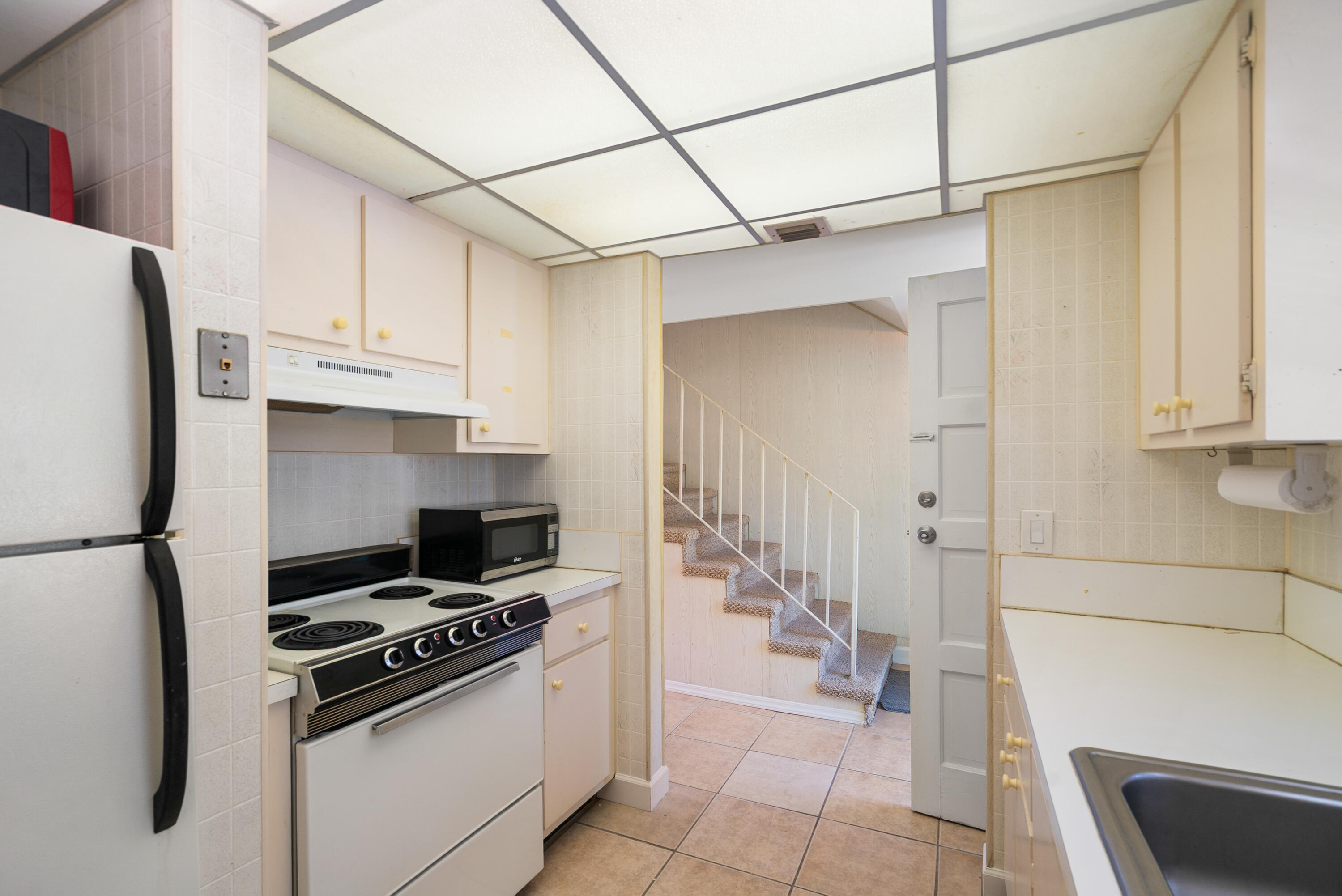 300 Ocean Drive, Unit 23 Key Largo, FL 33037 - Photo 8 of 29 a kitchen with stainless steel appliances granite countertop a refrigerator and a stove top oven