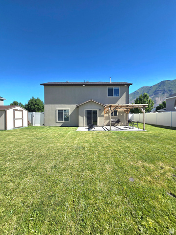 601 West 150 North, Unit 25 Springville, UT 84663 - Photo 27 of 29 Expansive backyard featuring a lush lawn, concrete patio, and a built-in wooden pergola