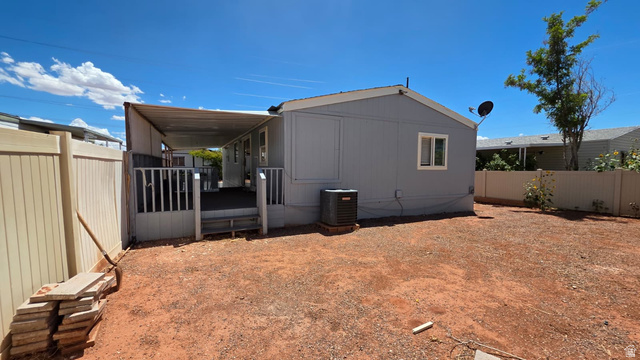 1450 North Dixie Downs Road, Unit 51 St. George, UT 84770 - Photo 14 of 25 Expansive backyard featuring a covered patio, privacy fencing, and an external HVAC unit