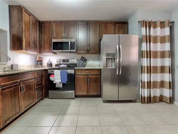 a kitchen with stainless steel appliances granite countertop a refrigerator and a sink