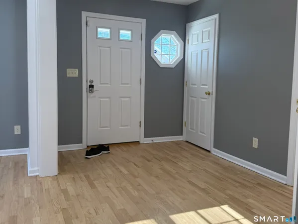an empty room with wooden floor and mirror