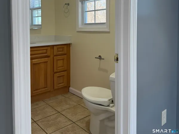 a bathroom with a granite countertop toilet and a sink