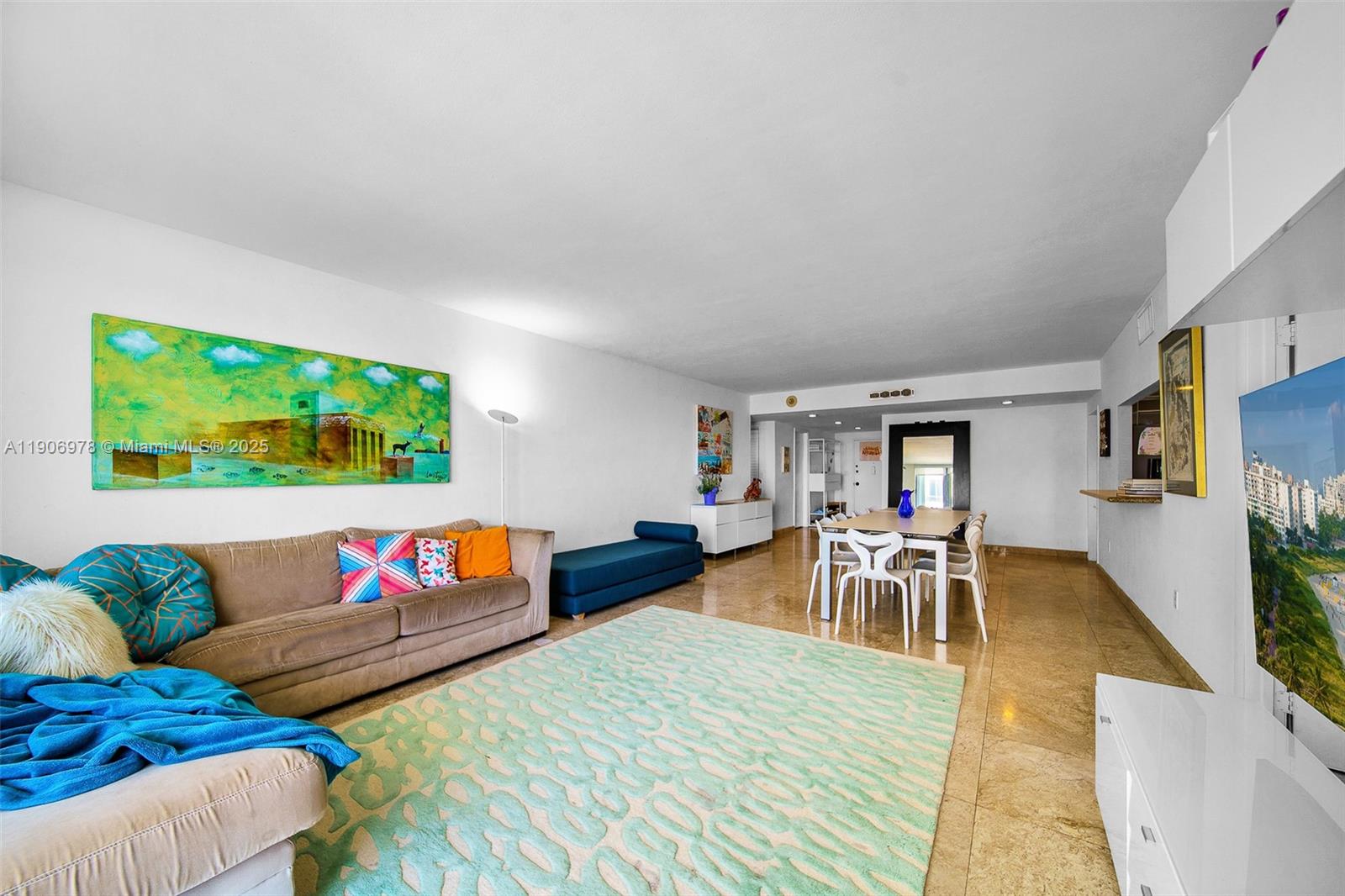 5825 Collins Avenue, Unit 10G Miami Beach, FL 33140 - Photo 13 of 51 a living room with furniture and a flat screen tv