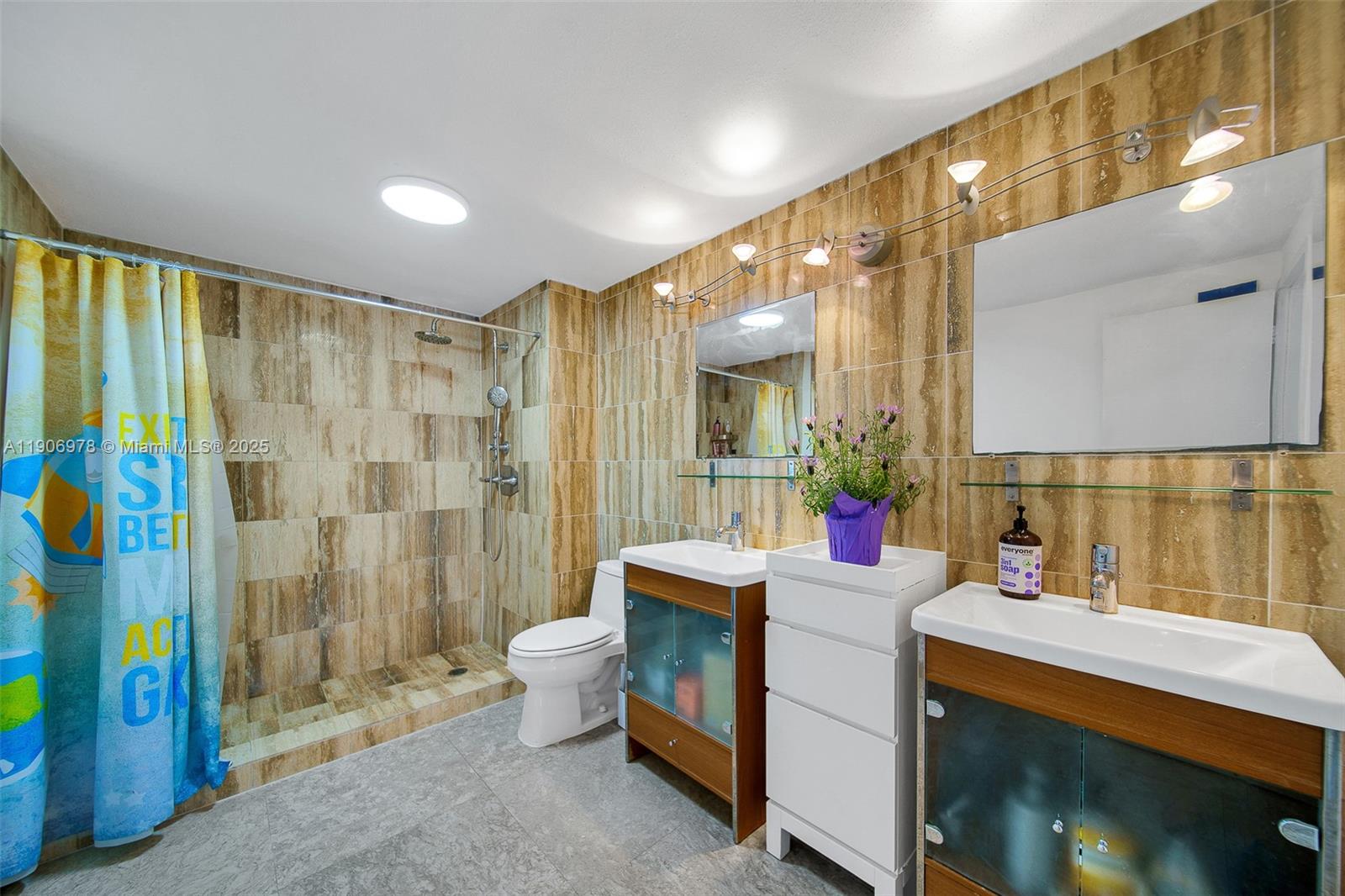 5825 Collins Avenue, Unit 10G Miami Beach, FL 33140 - Photo 17 of 51 a bathroom with a sink mirror and shower